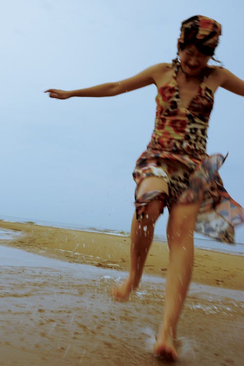 A woman in a dress running on the beach