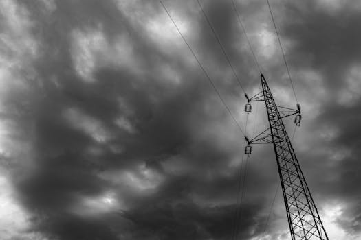 Black and white image of a power tower with dramatic cloudy sky in Garešnica, Croatia.