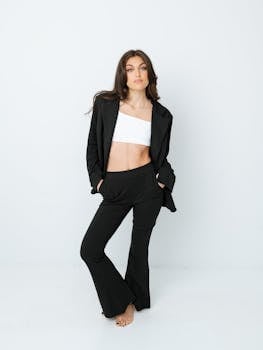 Portrait of a fashionable woman in a black suit on a white background, exuding confidence.