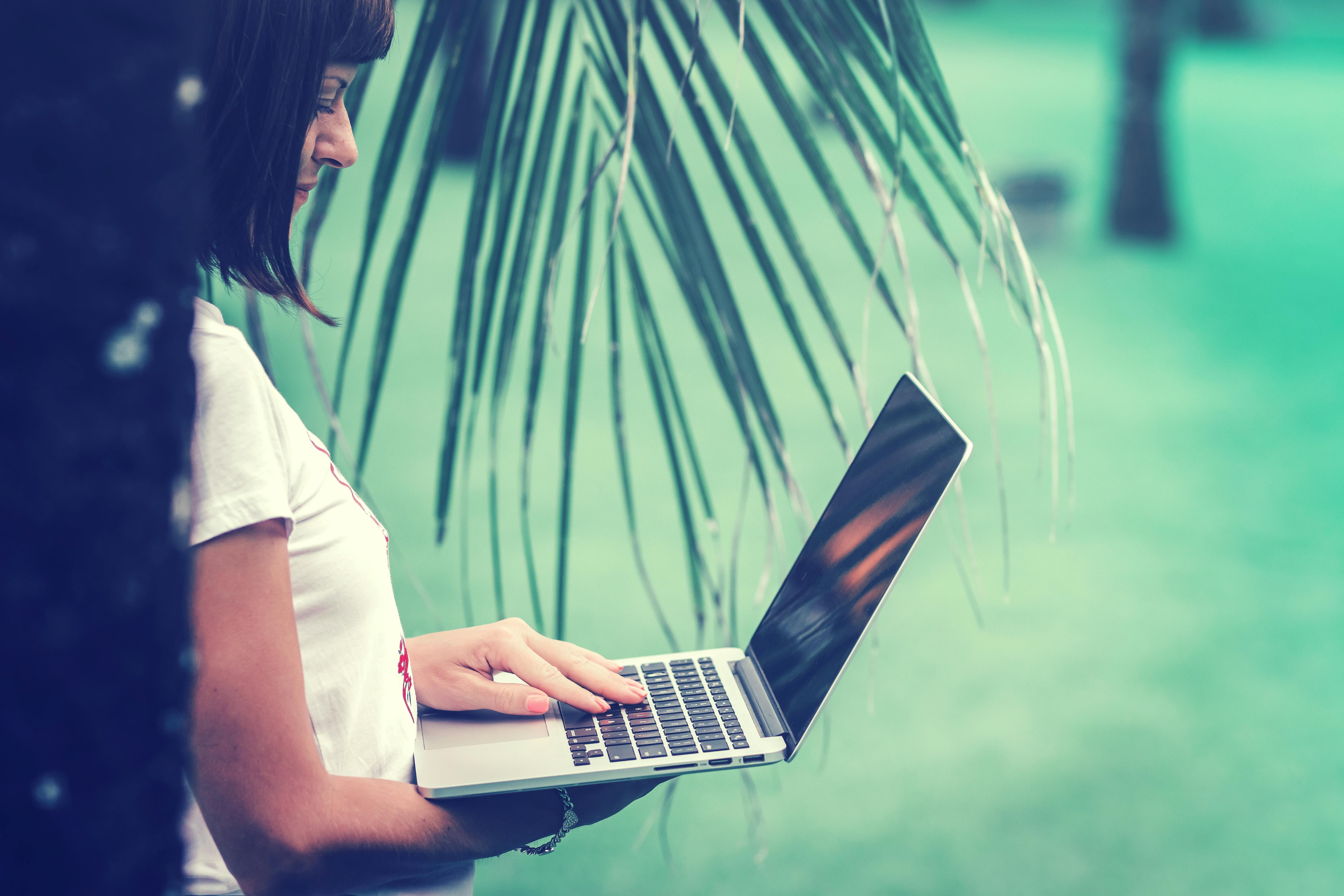 Woman in White T-shirt Using Macbook Pro