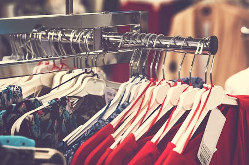 Assorted Clothes With Hangers on Display Rack