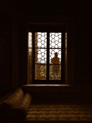 Figure silhouetted against a bright window — photo by Nisasu on Pexels