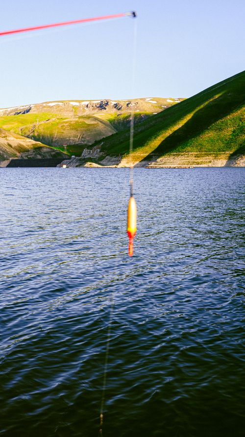 Free Peaceful fishing line with lure in scenic Erzurum, Türkiye lake view. Stock Photo
