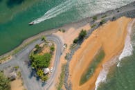 阳光明媚的天气里，一张热带海滩、道路与小船的惊人鸟瞰图，是理想的旅行与自然主题