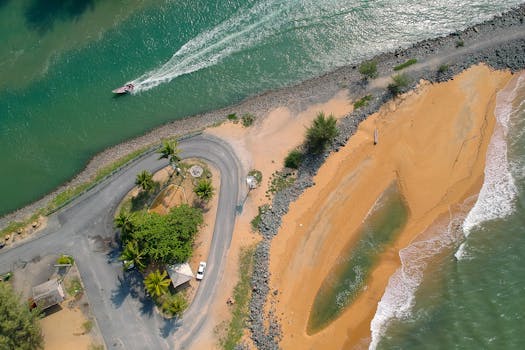 阳光明媚的天气里，一张热带海滩、道路与小船的惊人鸟瞰图，是理想的旅行与自然主题