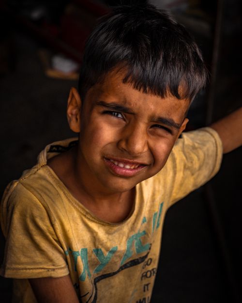 Free Portrait of a young boy with a yellow t-shirt, showcasing an intense expression. Stock Photo