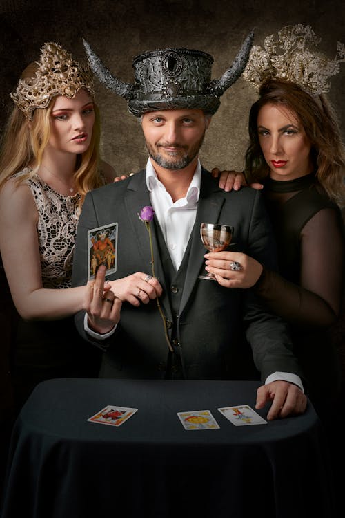 Man Wearing Gray Suit Jacket Holding Tarot Card