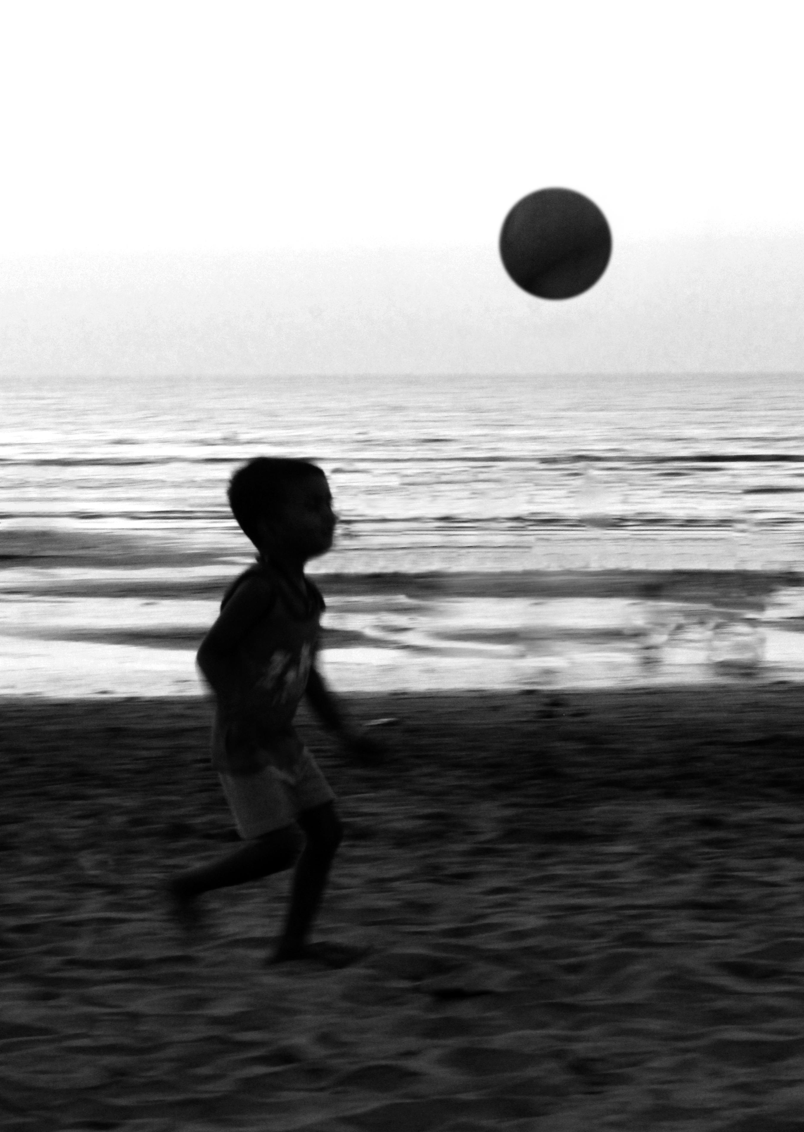 Boy Playing on Beach Against Sky
