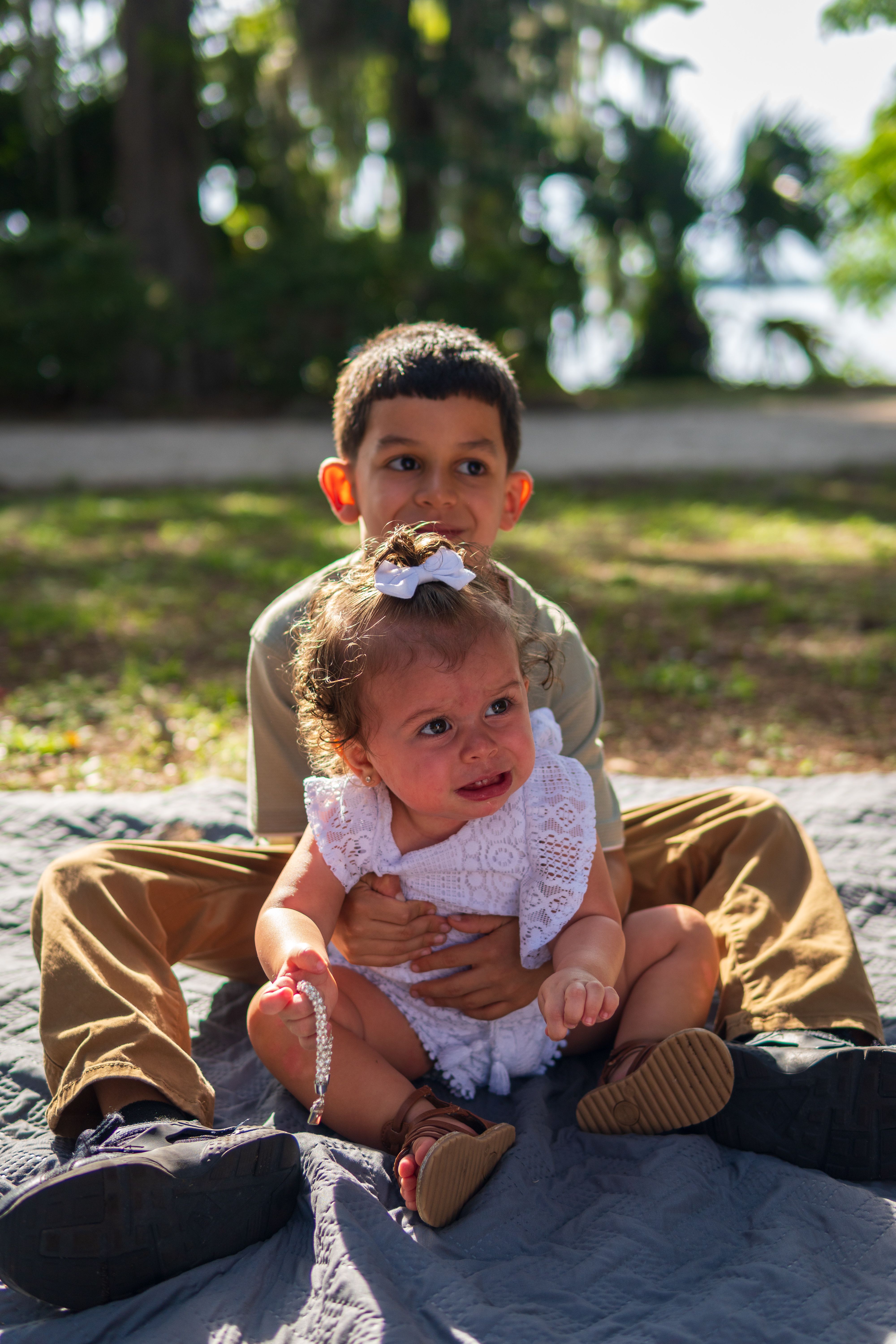 Fotomural Niño pequeño abrazando cariñosamente a su hermanita durante un picnic al aire libre soleado.