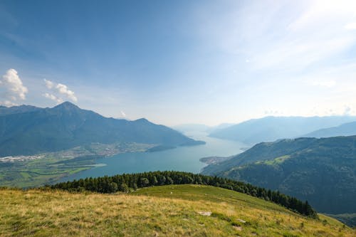 A view of a mountain with a lake and mountains in the background