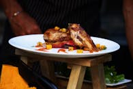 白色盘子里放着美味的烤鸡和五颜六色的蔬菜，随时可以享用