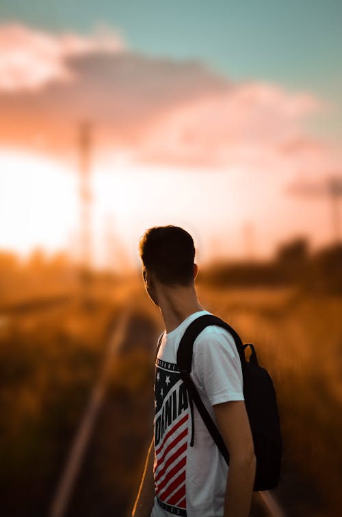 Selective Focus Photography of a Man in White Printed T-Shirt Carrying Backpack