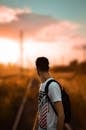 Selective Focus Photography of a Man in White Printed T-Shirt Carrying Backpack