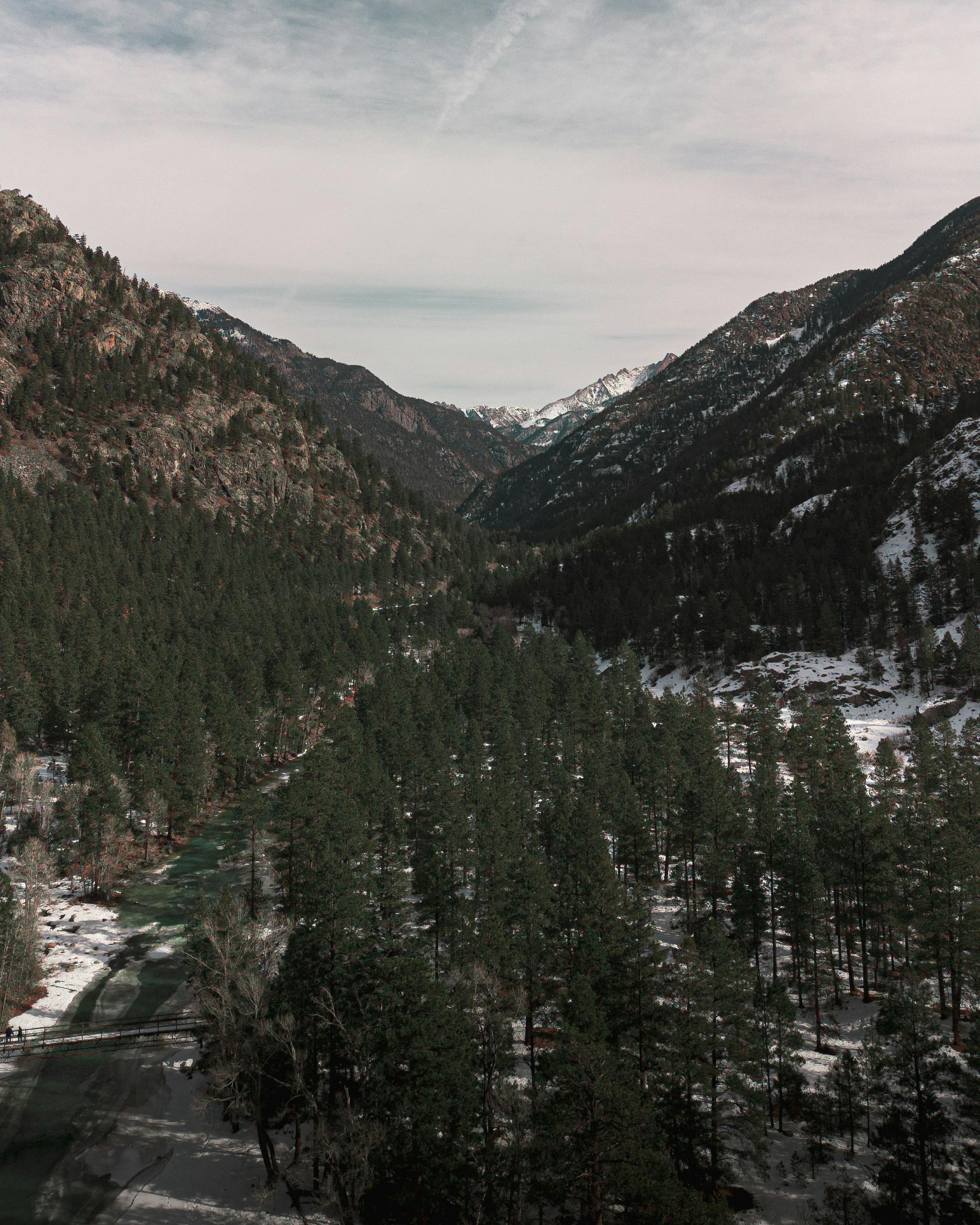 a view of a river and mountains in the winter