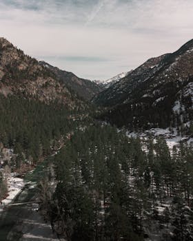 Discover the serene beauty of Colorado's snow-covered mountains and lush forests during winter.