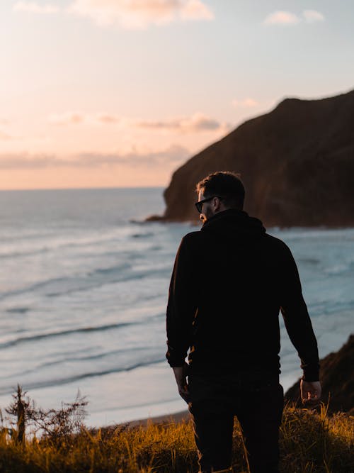 Man in Black Hoodie Standing Near Shore