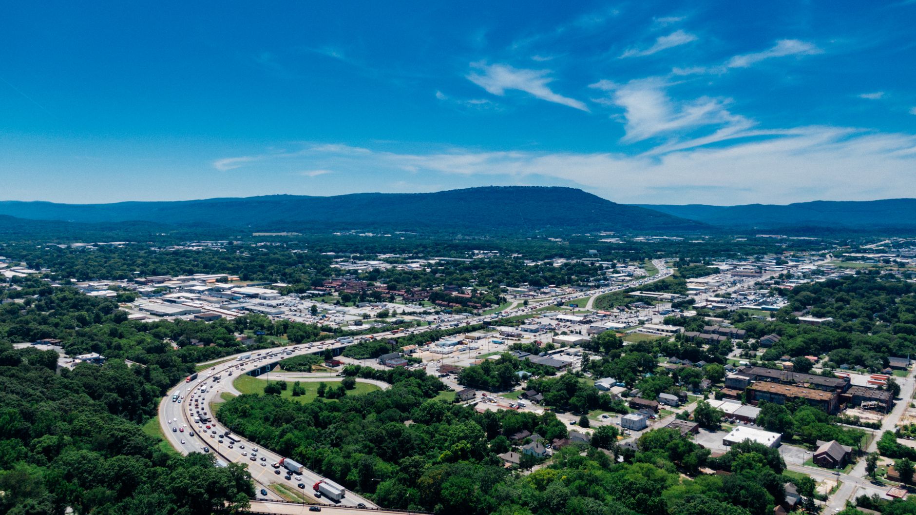 A stunning aerial view of Chattanooga, Tennessee, capturing the vibrant cityscape under a clear summer sky.