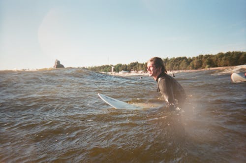 Person Wearing Black Wet Suit on Body of Water