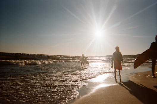 冲浪者在风景优美的海滩上欣赏海浪上的日出