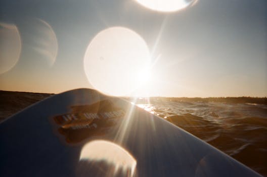 迷人的日落景象在海浪与冲浪板之间