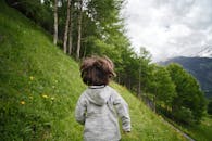 Toddler Wearing Gray Hoodie Running on Green Fields