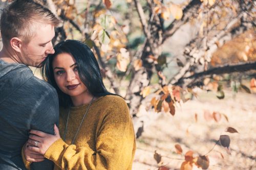 Free A loving couple embracing in an autumn park, surrounded by colorful leaves. Stock Photo
