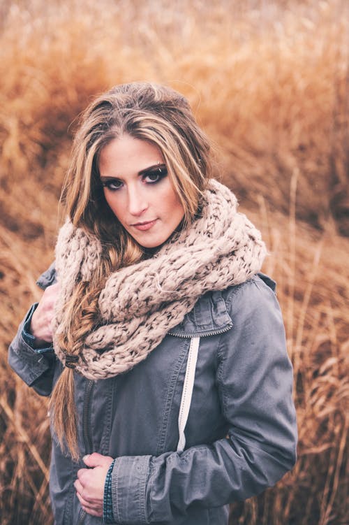 Selective Focus Photo of Woman in Blue Jacket and Knitted Scarf Posing