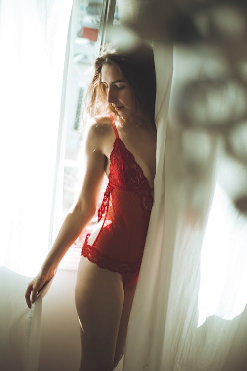 Women in Red Lingerie Standing Behind White Curtain
