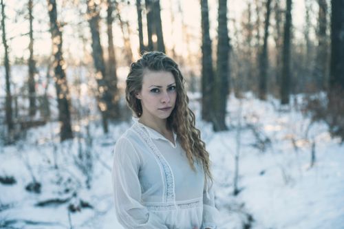 Free Captivating portrait of a woman in a snowy forest, expressing serene beauty. Stock Photo