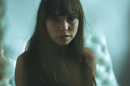 这是一幅艺术肖像，画中女子长发披肩，留着刘海，背景柔和而富有情绪