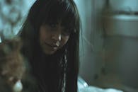 一幅迷人的低光肖像描绘了一位留着刘海的女性，传递出一种神秘的情绪