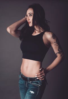 Portrait of a confident woman in casual wear posing with tattoos, highlighting her style.