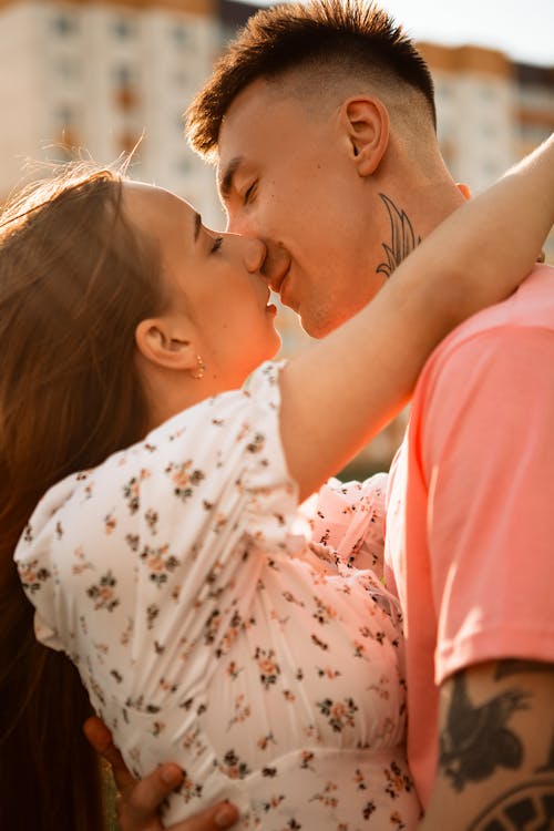 A couple kissing in front of a building