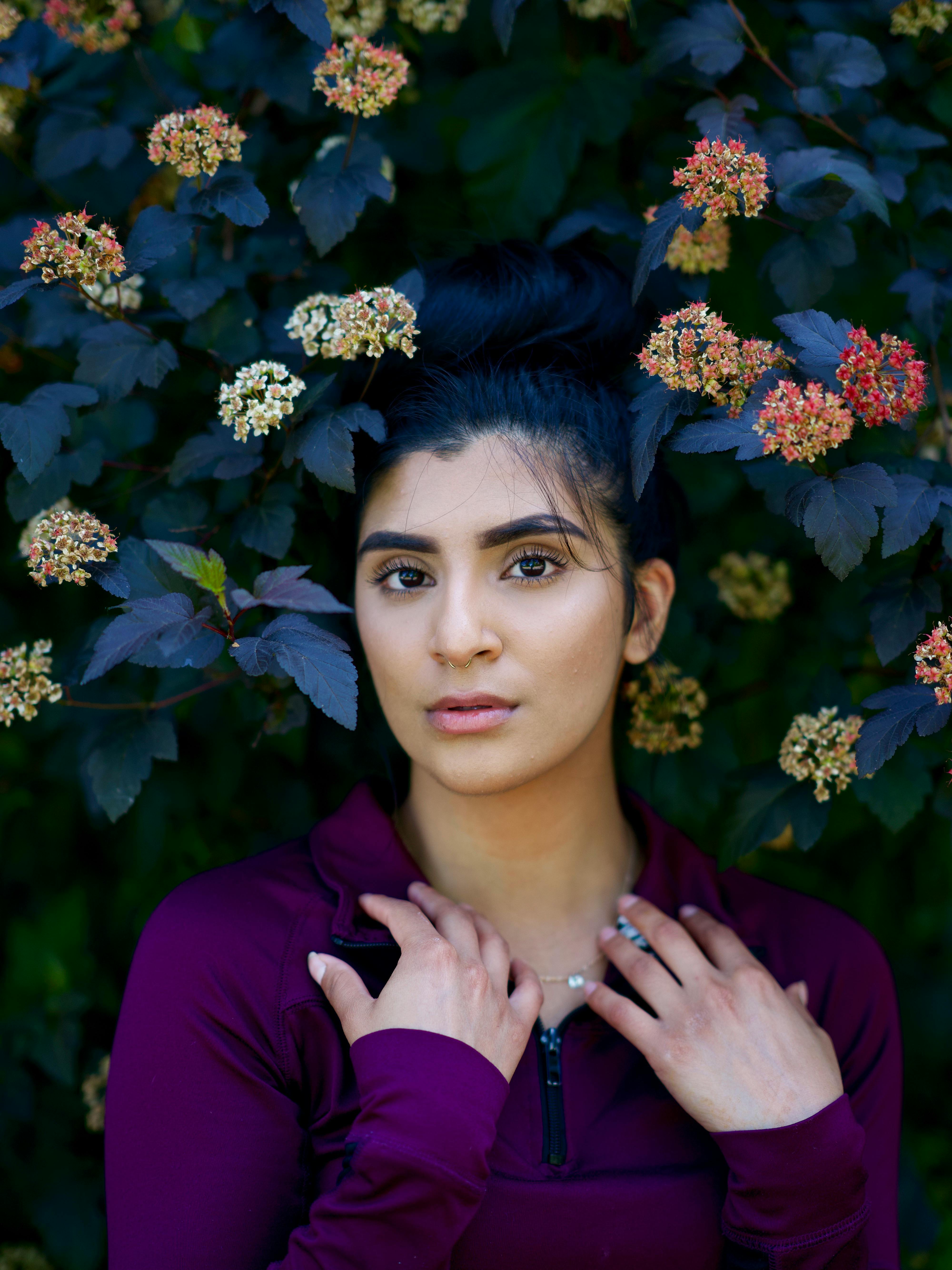 一幅迷人的女性肖像被充满活力的花园花朵环绕，散发着自然之美