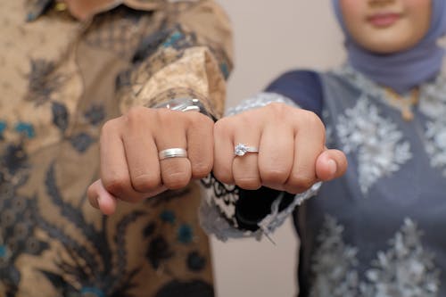 A couple holding hands with wedding rings on their fingers