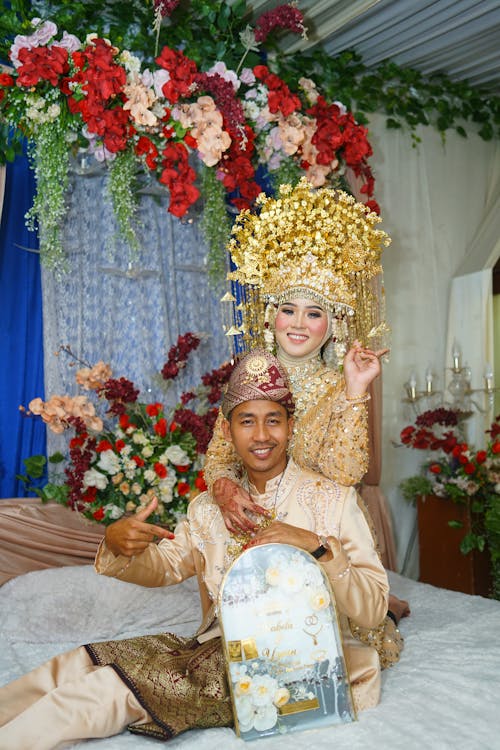 A man and woman in traditional attire pose for a photo