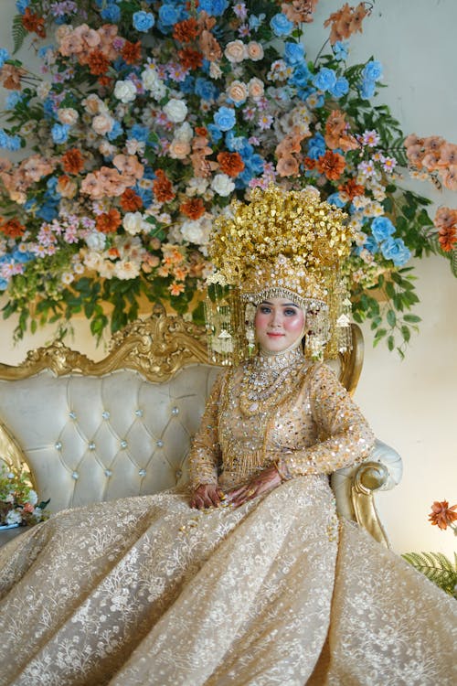 A woman in a gold dress sitting on a throne