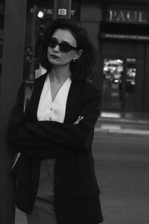 Free Stylish woman in sunglasses poses elegantly on city street, reflecting urban fashion. Stock Photo