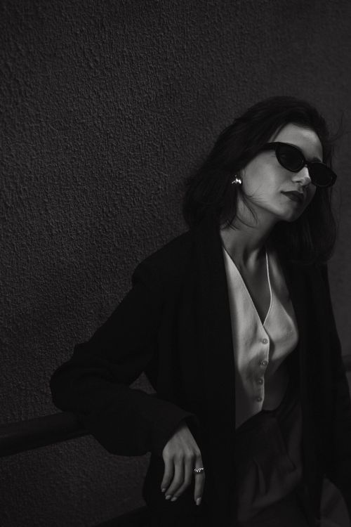 Free Black and white portrait of an elegant woman wearing sunglasses and a sophisticated outfit. Stock Photo