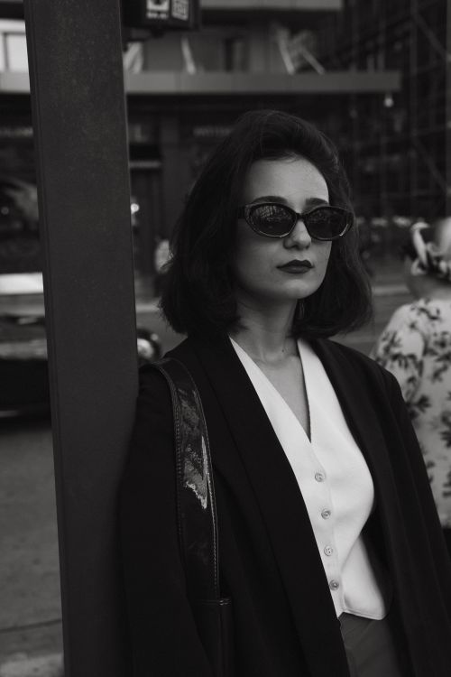 Free Chic woman in sunglasses poses confidently in Baku city street, capturing urban fashion style. Stock Photo