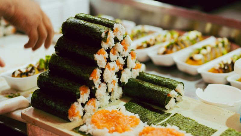 Freshly prepared sushi rolls neatly stacked at a restaurant counter, showcasing culinary artistry.
