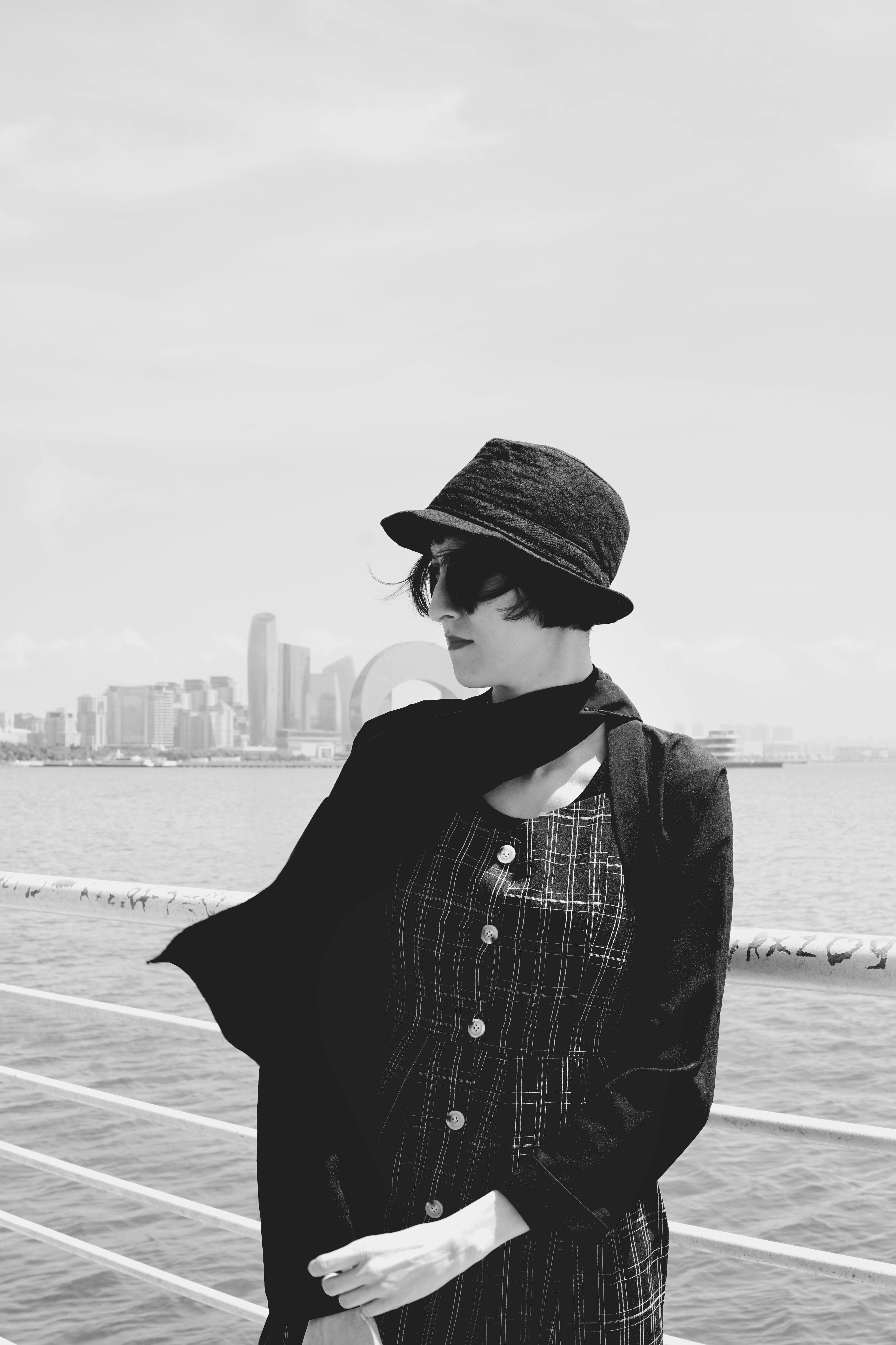 Chic woman in black attire with city skyline of Baku in the background.