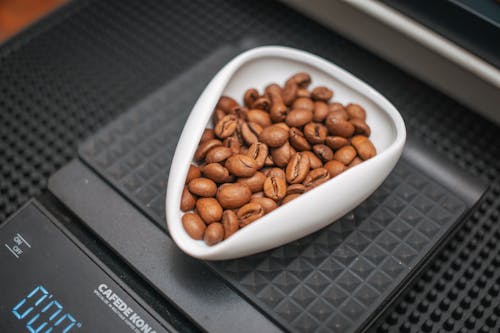 A bowl of coffee beans on a scale
