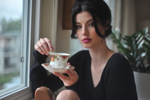Woman Holding White Saucer And Teacup