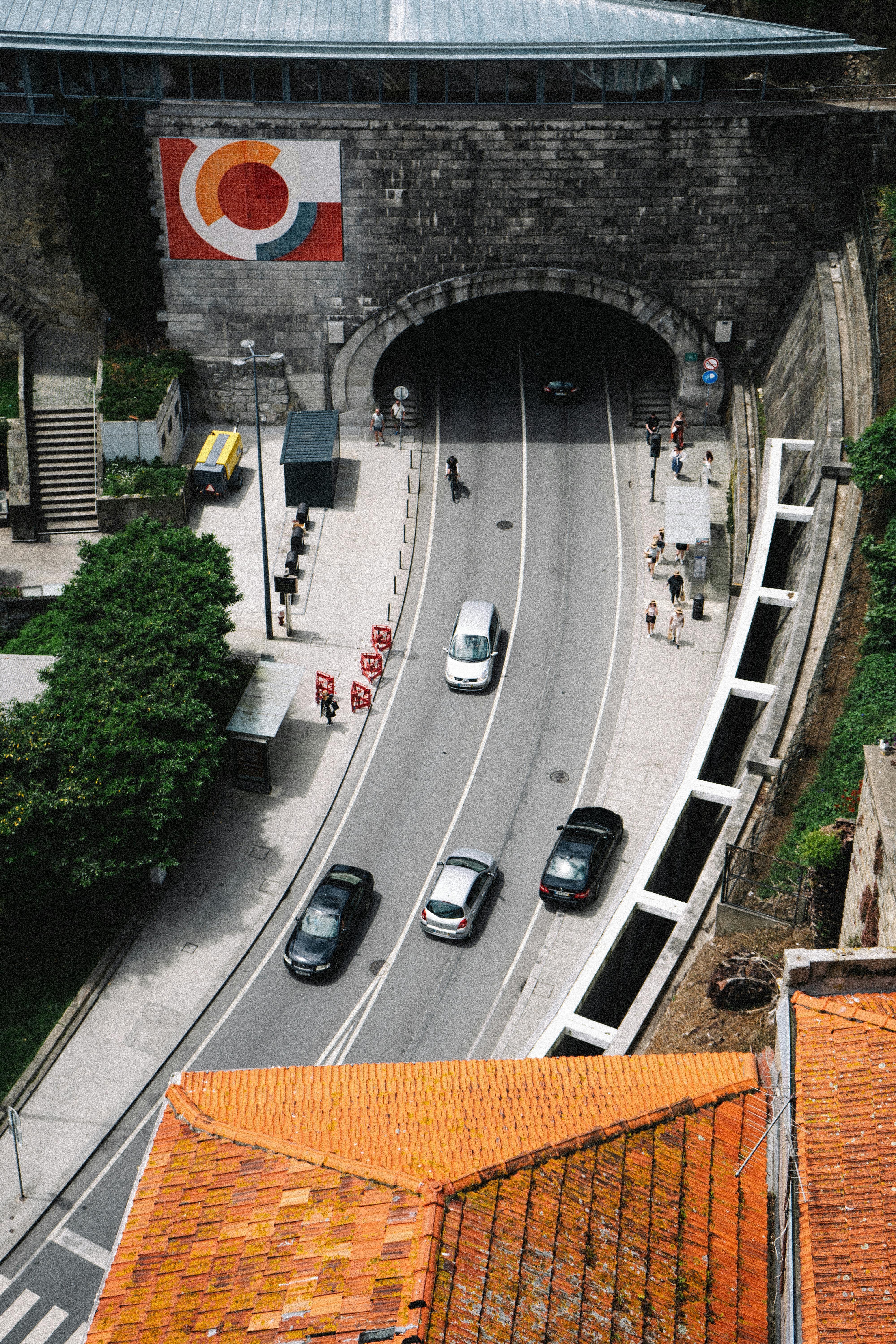 Top-down view of Santo António Tunnel in Porto with city traffic and red rooftops.