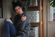 一名黑发女子身着休闲装，在室内优雅地摆着姿势，营造出宁静的氛围