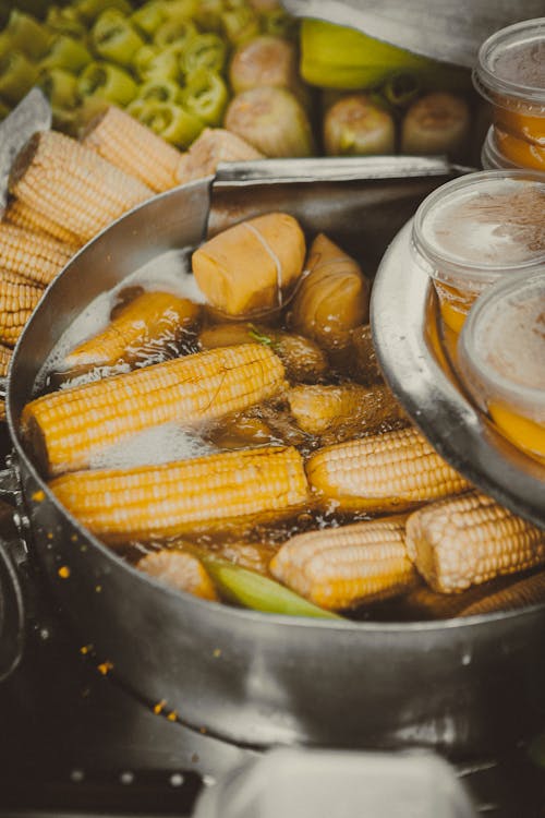 A pan filled with corn and other food