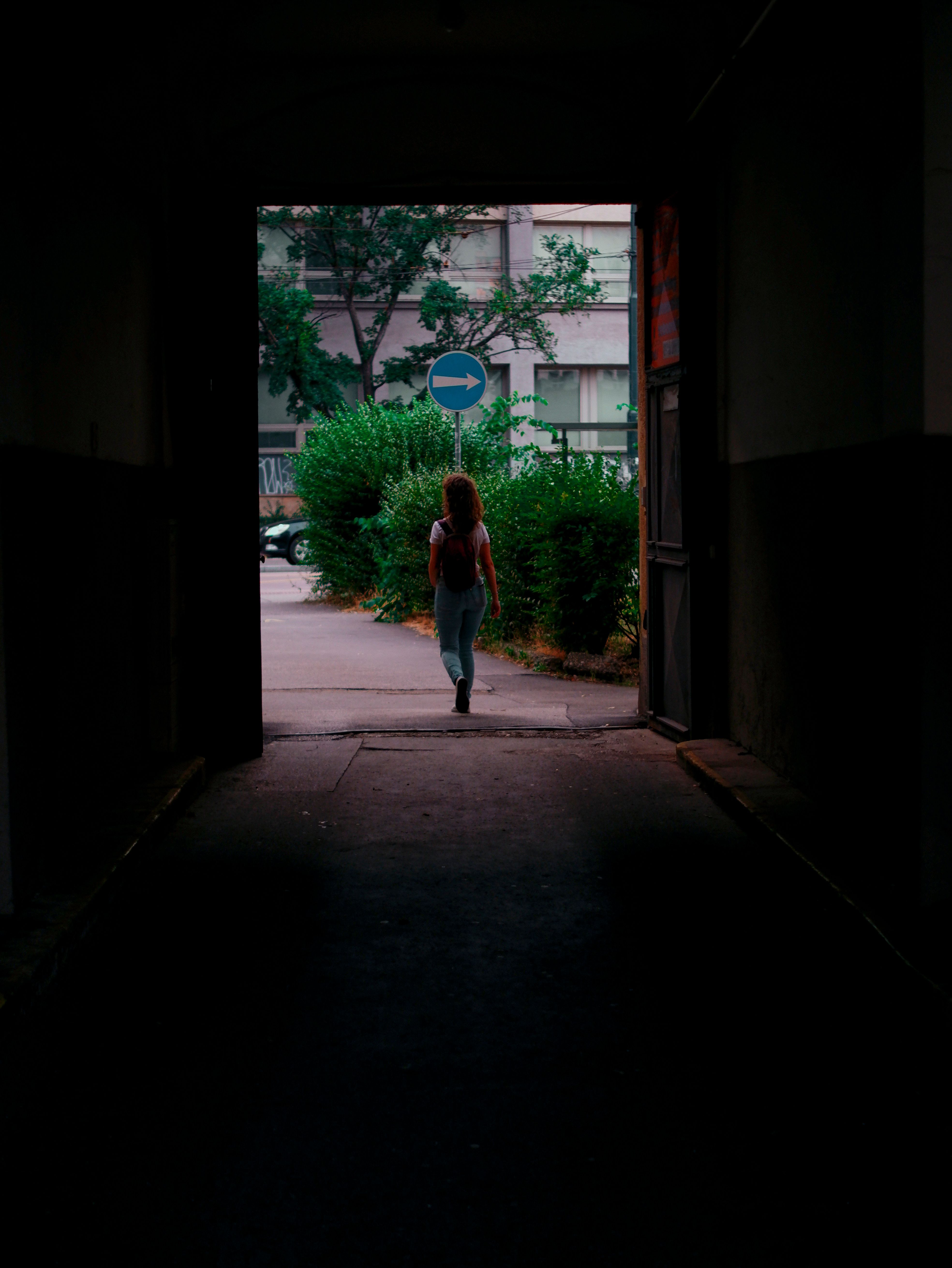 Back View of a Woman Walking Out of the Tunnel · Free Stock Photo