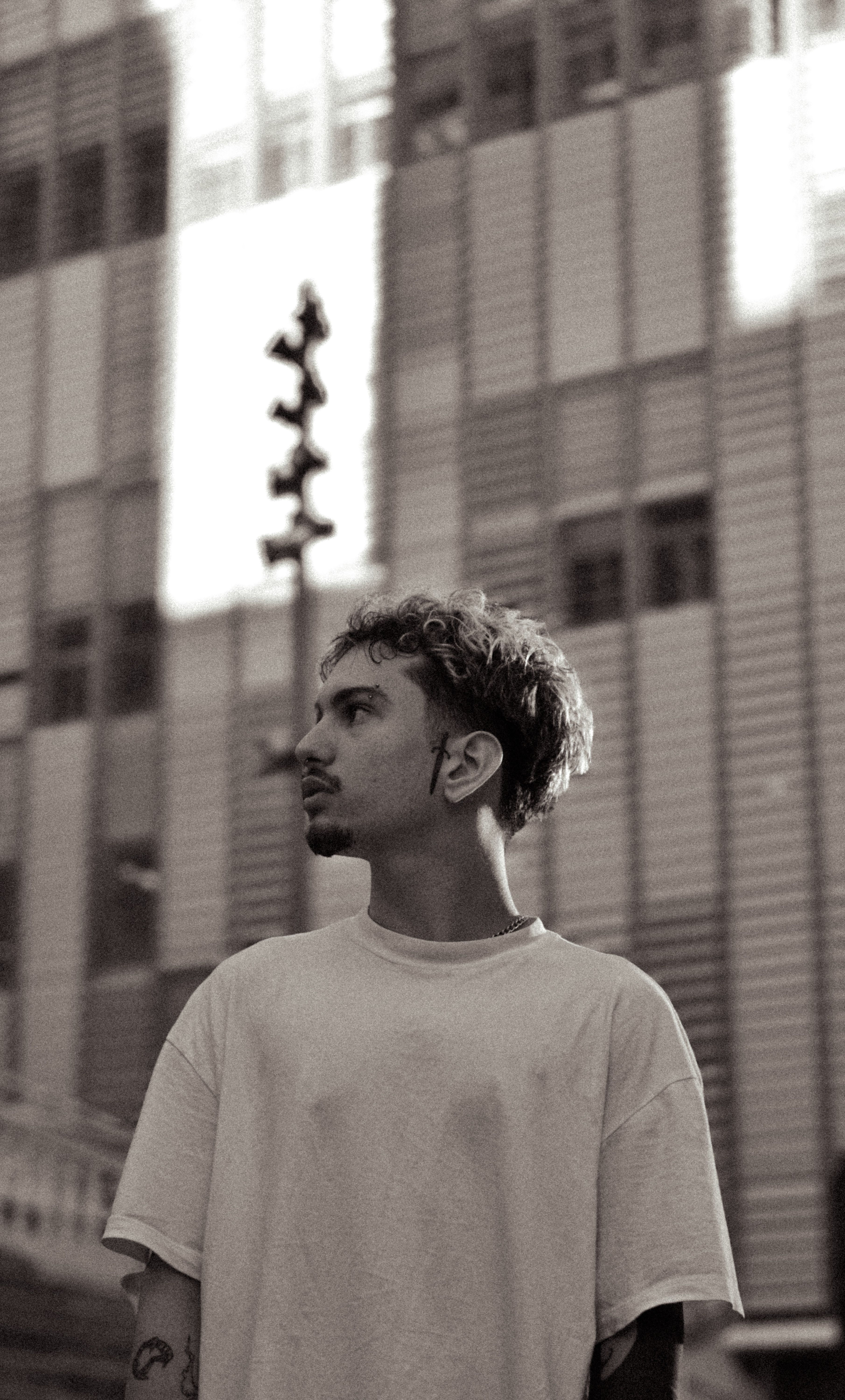 Stylish black and white portrait of a young man in an urban setting, exuding modern charm.