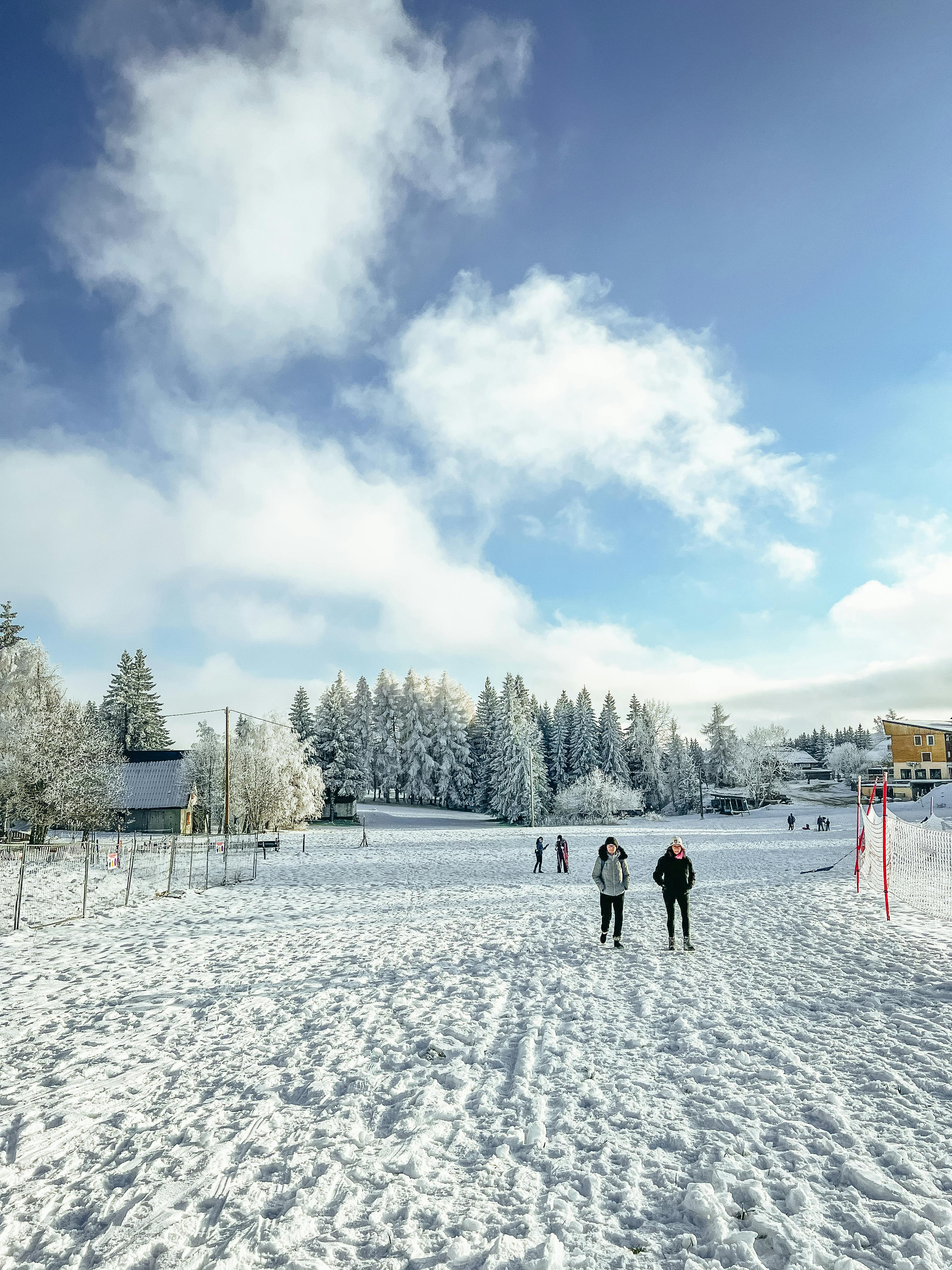 Prescription Goggle Inserts - Two people walk through a snowy landscape in Chambéry, surrounded by frost-covered trees.